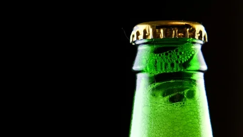 A closed beer bottle rotates on a black background. Stock Footage 126311052