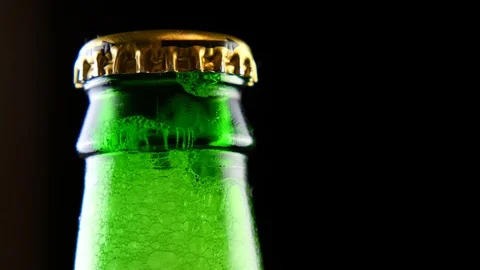 A closed beer bottle rotates on a black background. Stock Footage 126311067