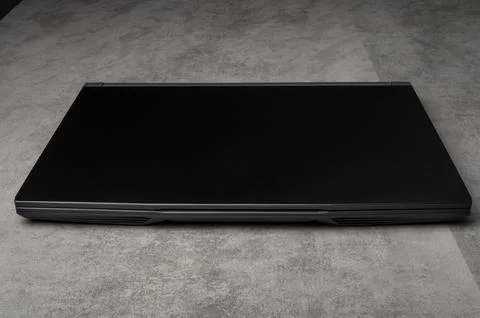 Closed black laptop computer on gray background  technology concept Stock Photos