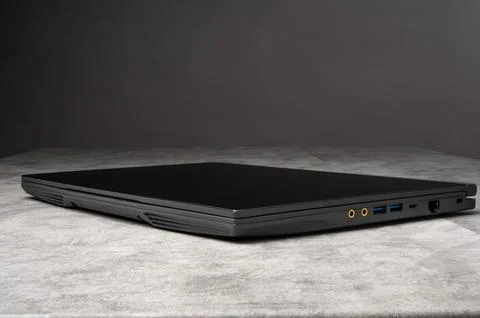 Closed black laptop computer on gray background  technology concept Stock Photos