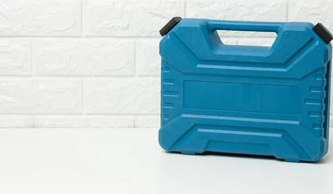 Closed blue plastic tool case stands on a white table Stock Photos