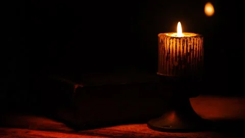 Closed Book Of Ancient Scriptures With Light From A Burning Candle Attached. Stock Footage 146071475