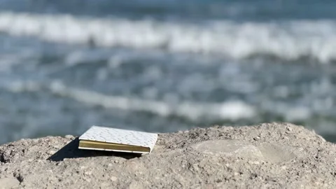 Closed Book on a beach, on background of sea waves Stock Footage 235900627
