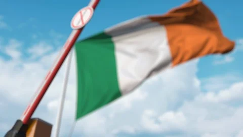 Closed boom gate with STOP CORONAVIRUS sign on the Irish flag background Stock Footage 126045692