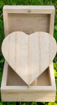 Closed box in the shape of a heart in an open wooden cube box Stock-Fotos