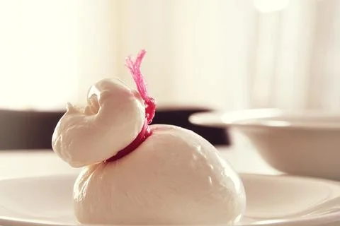 Closed burrata cheese on the white plate on the kitchen Foto stock