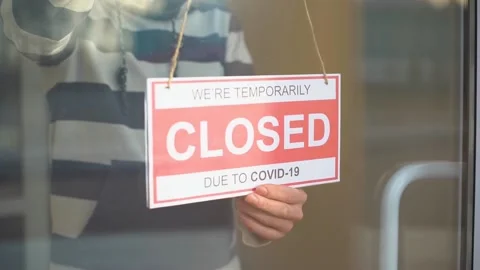 Closed for business due to covid. Small shop puts closed sign up on storefront Stock Footage