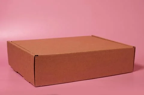 Closed cardboard box on a solid pink background Stock Photos