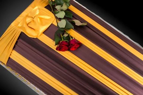 Closed coffin with two red roses covered with elegant cloth isolated on gray Photos