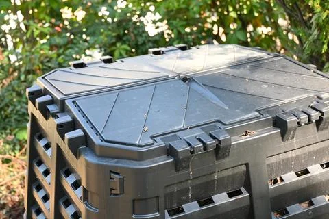 Closed compost bins in a leafy garden Stock Photos