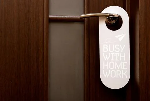 Closed door, do not disturb sign hanging on the handle, busy with home work Photos