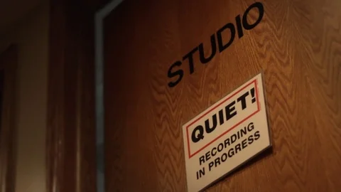 A closed door to a recording studio with a please be quiet sign Stock Footage