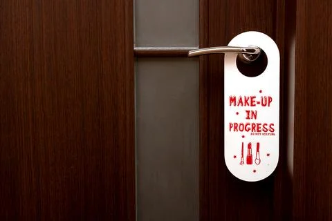 Closed door, a sign on the handle Do Not Disturb Make-up in Progress Stock Photos