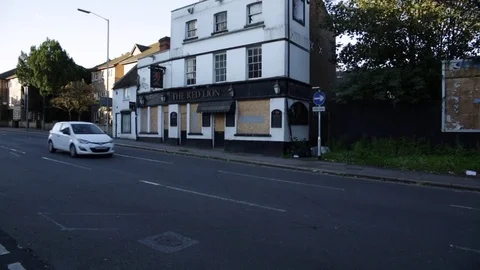 Closed down and boarded up pub in England - tilt Stock Footage 79960716