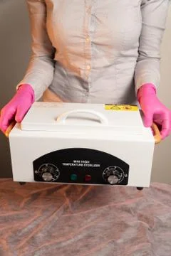 Closed dry sterilization of instruments in hands holds Stock Photos