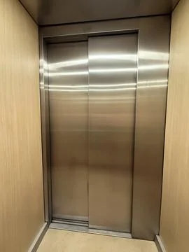 Closed elevator doors made of stainless steel inside residential building. .. Stock Photos