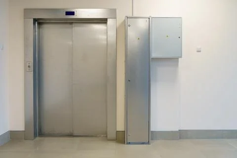 Closed elevator doors. Shiny metal elevator doors in a new modern elevator. A Stock Photos