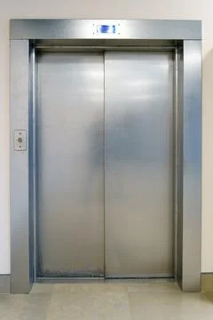 Closed elevator doors. Shiny metal elevator doors in a new modern elevator. A Stock Photos