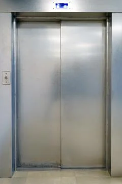 Closed elevator doors. Shiny metal elevator doors in a new modern elevator. A Stock Photos