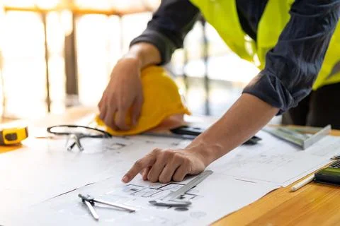 Closed up engineer architect pointing to a building plan on a blueprint Stock Photos