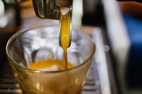 Closed up espresso machine brewing coffee into glasses shot in cafe. Stock Photos