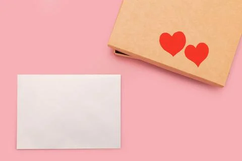 Closed gift box and two paper hearts on it isolated on pink background Stock Photos