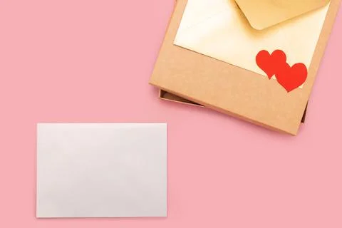 Closed gift box and two paper hearts on it isolated on pink background Stock Photos