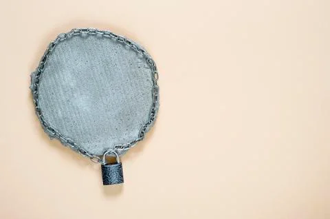 Closed lock of the fence with the square grey piece of concrete with a metal Stock Photos