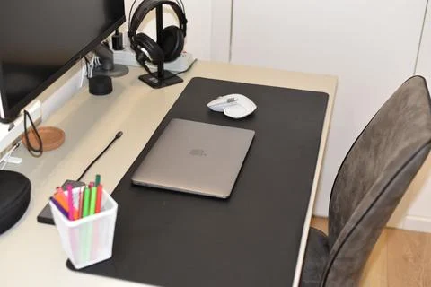Closed MacBook laptop, Logitech mouse on a work desk Stock Photos