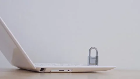 Closed metal lock placed on notebook computer for symbolizing digital privacy Stock Footage 328591936
