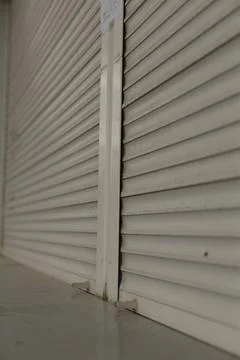 Closed metal roller shutter door with locking bar Stock Photos