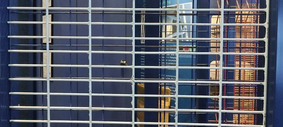 A closed metal security gate with horizontal bars 스톡 사진