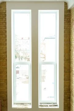 Closed new PVC windows with double glazing in the room. Installation and main Stock Photos