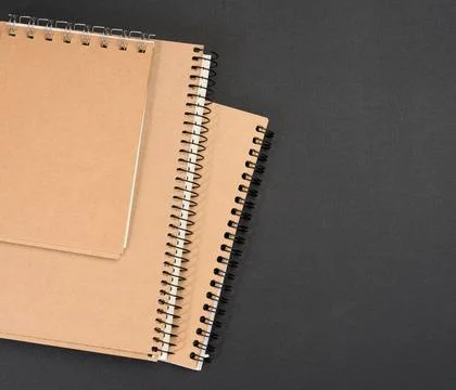 Closed notepad with brown sheets on black background Stock Photos