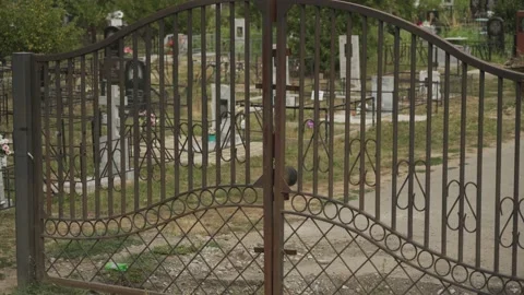 Closed old rusty black wrought iron gate in the cemetery close up. Front view Stock Footage 143841438