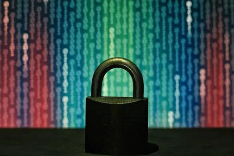 Closed padlock in front of matrix style computer language binary data code. b Stock Photos