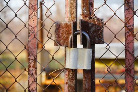 Closed padlock hanging on the hinges Stock Photos