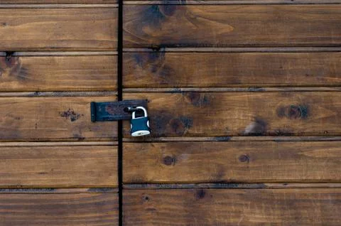Closed padlock on a painted brown pine wooden door Stock Photos