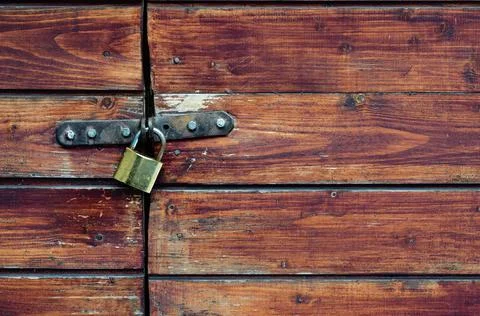 Closed padlock on a painted brown pine wooden door Stock Photos
