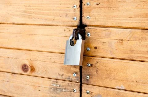 Closed padlock on a painted brown pine wooden door Stock Photos