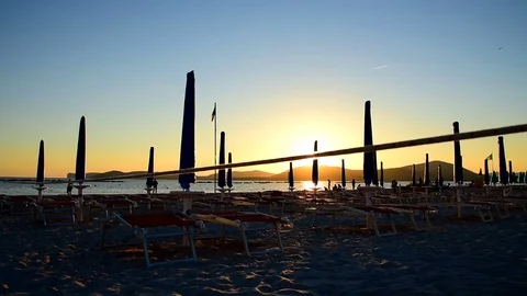 Closed parasols by the sea at sunset Stock Footage 76742871