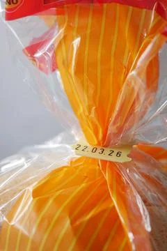 Closed plastic bag with bread tied and marked with expire date Stock Photos