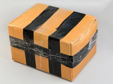 Closed rectangular kraft cardboard packing box rewound with black tape Stock Photos
