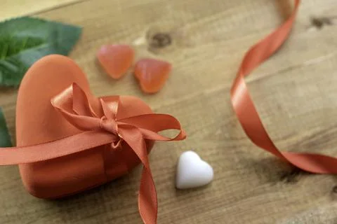 Closed red box in the shape of a heart with a red ribbon bow Stock Photos