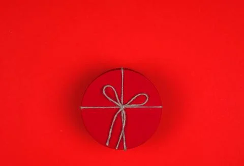 Closed red round gift box on red background. Top view. Gift for the holidays  Stock Photos