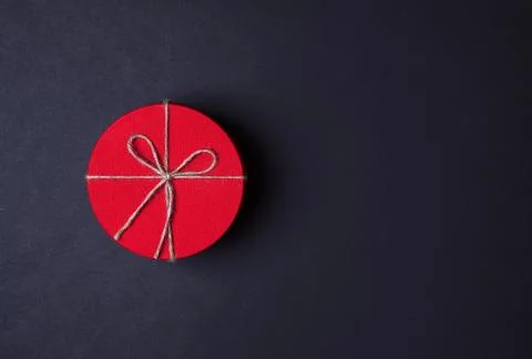 Closed red round gift box on black background. Top view. Gift for the holiday Stock Photos