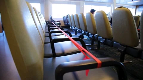 Closed off rows of seats on a ferry boat as a measure to maintain social Stock Footage 132368982