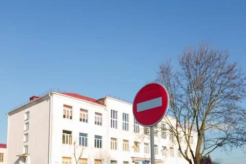 Closed school on blue sky background. Stop traffic sign on foreground. Stock Photos