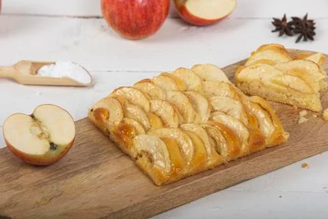 Closed shot of Portion of apple pie on wooden cutting board with various ingr Stock Photos