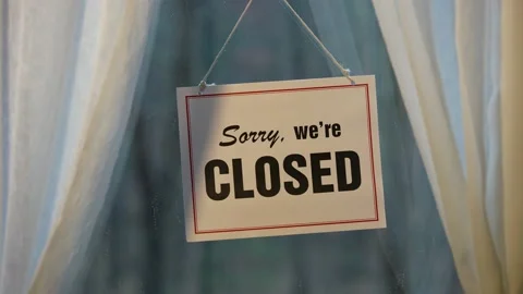 Closed sign hanging in the window of store front display in business concept Stock Footage 143146084